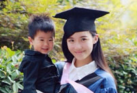 Female master poses for graduation photos with son