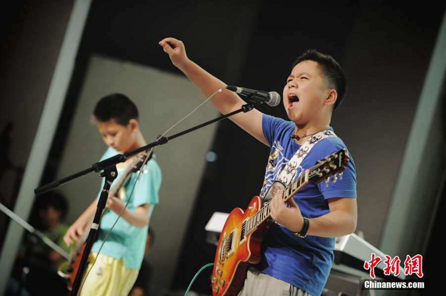 The 4th National Kids’ Rock Band Contest was held in Tianjin on Aug 10, 2014. Sixteen kids rock bands from various provinces of the country competed for the championship. Children rock n' roll music has become a hit recently in China with the development of modern music. More parents choose to have their children learn instruments like guitar, drums, or bass. (Chinanews/Tong Yu)