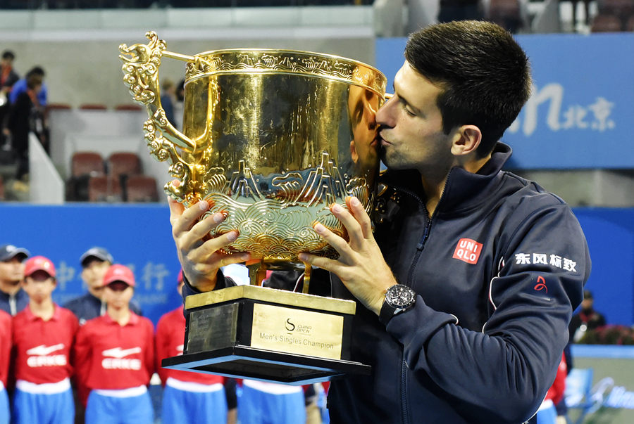 World No. 1 Novak Djokovic kisses the China Open trophy after winning his fifth title in Beijing on Sunday. (Li Zhenyu/People’s Daily Online)