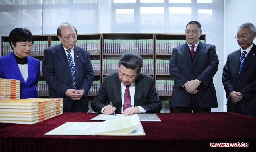 Chinese President Xi Jinping (C) presents books to the University of Macao during his visit to the University's new campus on Hengqin island, Dec. 20, 2014. (Xinhua/Lan Hongguang)