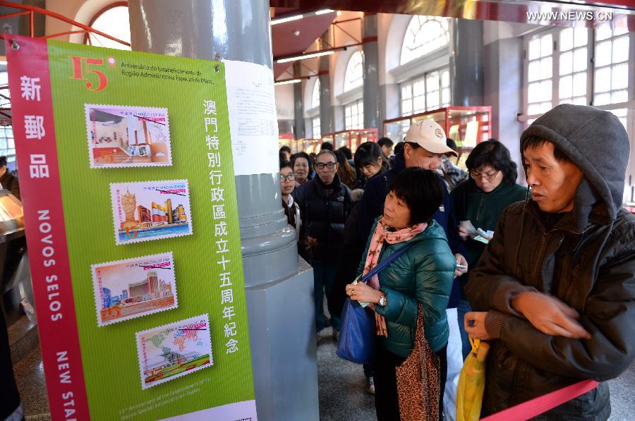 People wait in queue to purchase souvenir post stamps at a post office in Macao, south China, Dec. 20, 2014. The Macao Post issued souvenir stamp folders and two sets of philatelic items to mark the 15th anniversary of the establishment of the Macao Special Administrative Region (SAR) on Saturday. (Xinhua/Qin Qing)