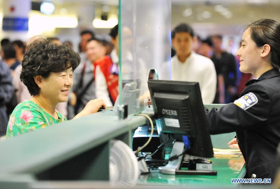 A passenger from South Korea (L) have her passport checked in Xiamen, southeast China's Fujian Province, April 2, 2015. The first group of passengers with a 72-hour visa-free stay in Xiamen reached Xiamen Gaoqi International Airport Thursday. Xiamen started to allow 72-hour transit visa exemptions for foreign nationals from 51 countries and regions from Wednesday. (Xinhua/Lin Shanchuan)