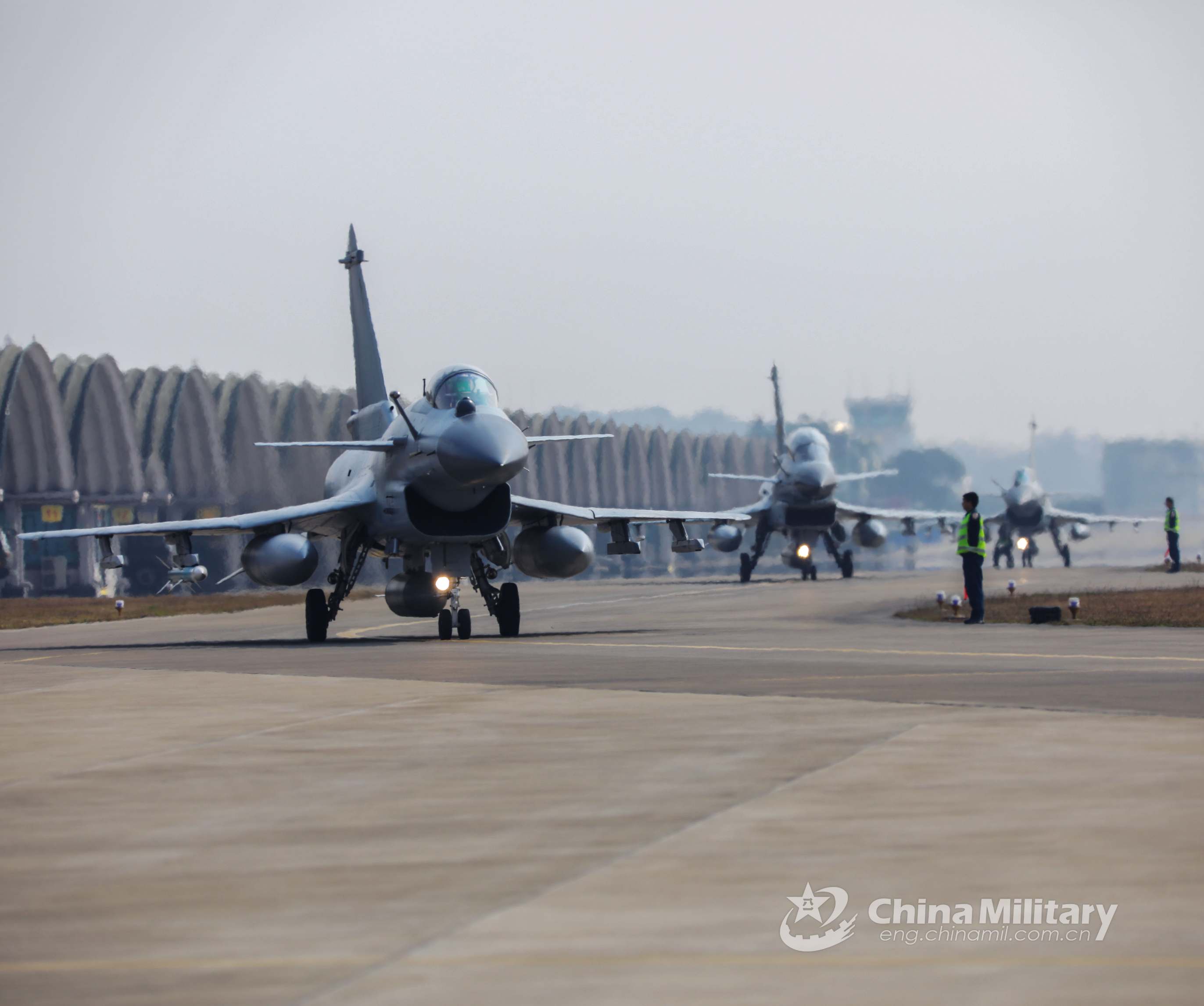 J-10 fighter jets attached to an aviation brigade of the air force under the PLA Southern Theater Command taxi in sequence out of the aircraft hangars in preparation for a flight training exercise on January 20, 2021. (eng.chinamil.com.cn/Photo by Wu Gaoming and Gu Haodong)
