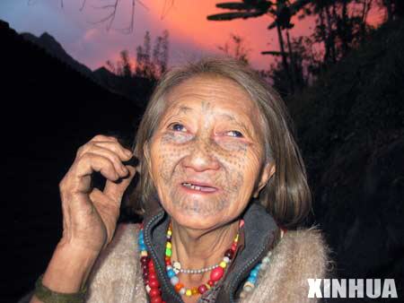 Lapei Nani of the Derung ethnic group shows her tattooed face in DrungNu