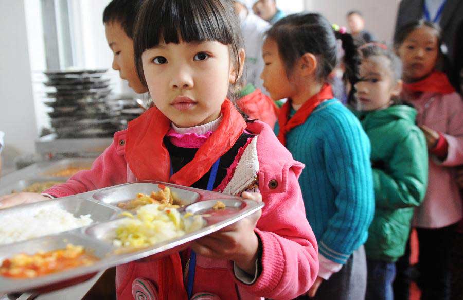 Hou Wanqi, whose parents are migrant workers, has lunch at the Longta Experimental Elementary School in southwest China's Chongqing Municipality, Nov. 6, 2012. Among the 706 students at the Longta Experimental Elementary School, about 150 are children of migrant workers. A total of 665 elementary schools in the city proper of Chongqing have accepted children of migrant workers, according to the municipality's education authorities. Children of migrant workers can enjoy free education and other subsidies at those schools. (Xinhua/Li Jian) 