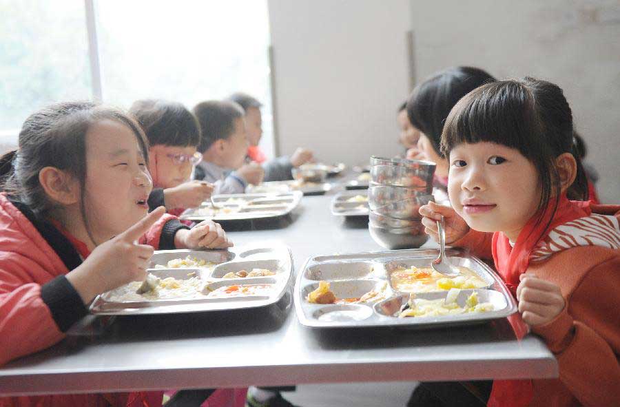 Shi Xinyi (R) and Qin Xiaoxiao (L), whose parents are migrant workers, have lunch at the Longta Experimental Elementary School in southwest China's Chongqing Municipality, Nov. 6, 2012. Among the 706 students at the Longta Experimental Elementary School, about 150 are children of migrant workers. A total of 665 elementary schools in the city proper of Chongqing have accepted children of migrant workers, according to the municipality's education authorities. Children of migrant workers can enjoy free education and other subsidies at those schools. (Xinhua/Li Jian)
