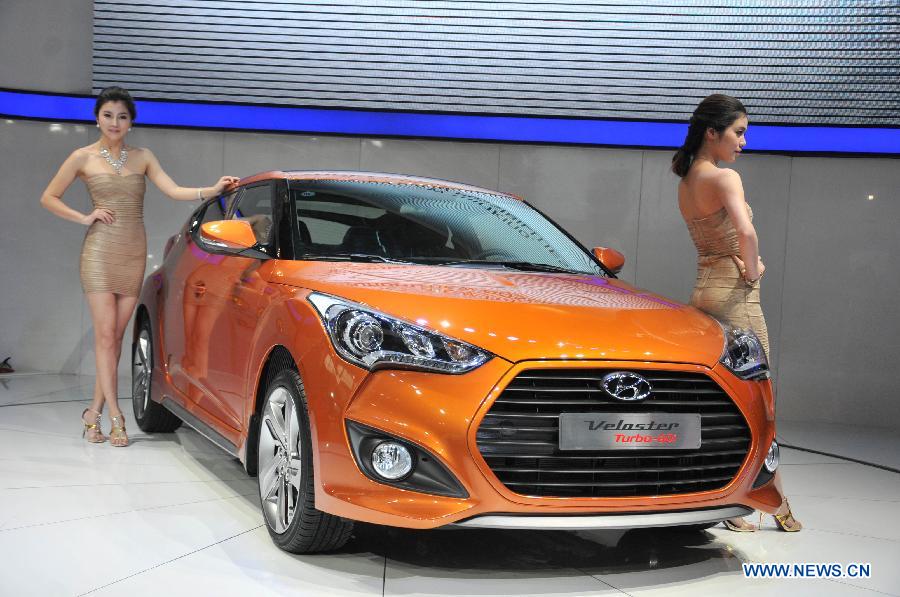 Models present a Hyundai Motor's Veloster car at the 13th International Automobile Industry Exhibition in Hangzhou, capital of east China's Zhejiang Province, Nov. 7, 2012. The five-day exhibition, which kicked off on Wednesday, displays vehicles of 60 brands from both home and abroad. (Xinhua/Zhu Yinwei)