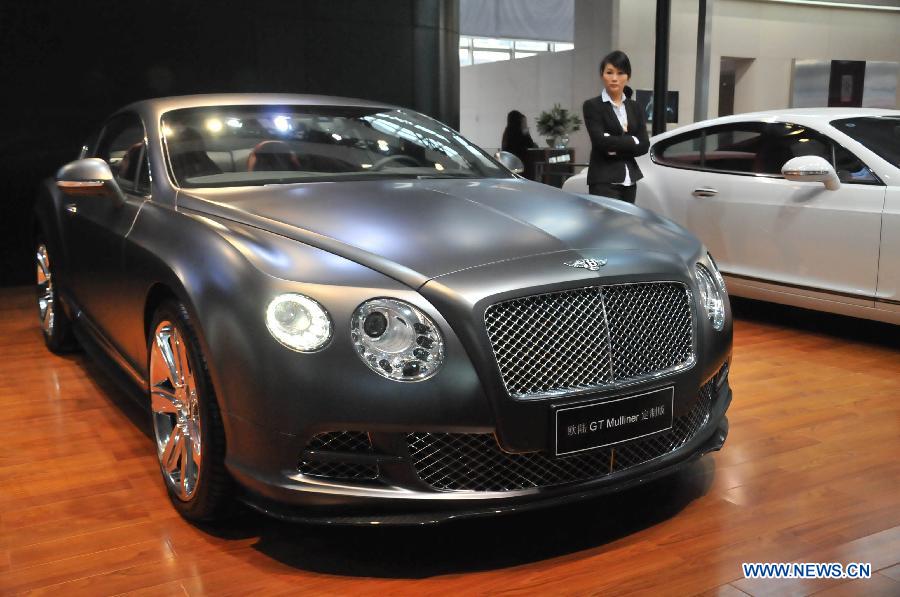 A staff member stands next to a Bentley GT car at the 13th International Automobile Industry Exhibition in Hangzhou, capital of east China's Zhejiang Province, Nov. 7, 2012. The five-day exhibition, which kicked off on Wednesday, displays vehicles of 60 brands from both home and abroad. (Xinhua/Zhu Yinwei)