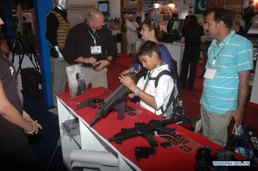 A child checks a rifle on display during the five-day International Defense Exhibition at the expo center in southern Pakistani port city of Karachi, Nov. 7, 2012. A total of 135 foreign and 74 Pakistani firms participated in the international defense exhibition which kicked off here on Wednesday. (Xinhua) 