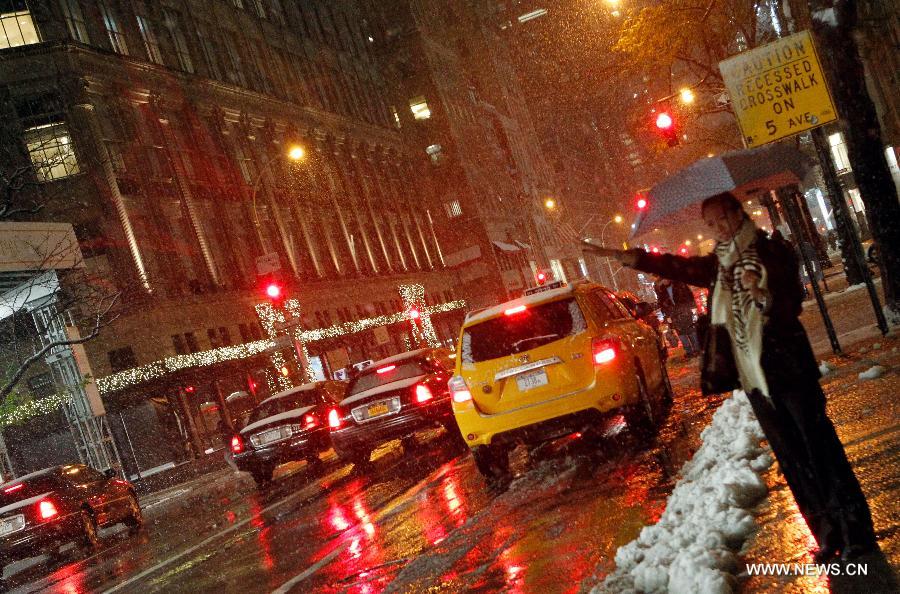 A woman waits for taxi in front of a store on the 5th Avenue in New York, the United States, Nov. 7, 2012. As New Jersey and New York are still trying to recover from the damage created by Hurricane Sandy, a Nor'easter named Winter Storm Athena dropped snow and rain on the Northeast on Wednesday, also bringing dangerous winds and knocking out power. (Xinhua/Wu Jingdan)