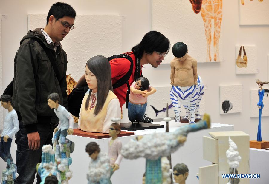 Visitors look at art works displayed at the exhibiton "Art Taipei 2012" in Taipei, southeast China's Taiwan, Nov. 8, 2102. "Art Taipei 2012" will take place from Nov. 9 to 12 at Taipei World Trade Center, displaying more than 2,000 art works from 150 galleries of 15 countries and regions. (Xinhua/Wu Ching-teng) 