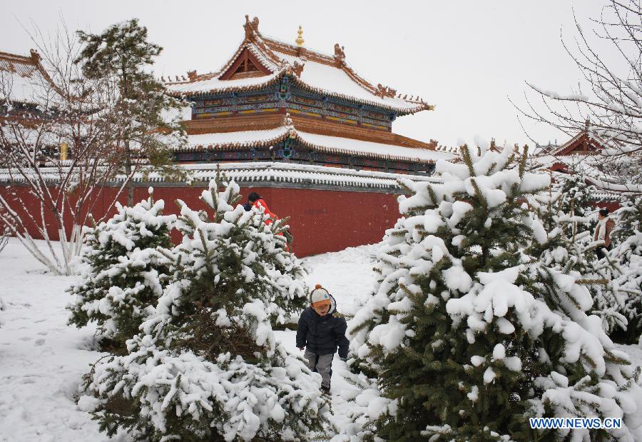 A child plays in a snow-covered field outside the Dazhao Temple in Hohhot, capital of north China's Inner Mongolia Autonomous Region, Nov. 10, 2012. A heavy snowfall hit Hohhot on Nov. 9. (Xinhua/Zhang Fan)