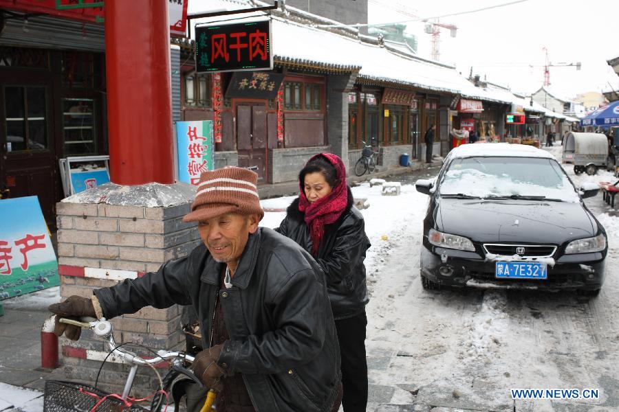 Pedestrians walk on a frozen road in Hohhot, capital of north China's Inner Mongolia Autonomous Region, Nov. 10, 2012. A heavy snowfall hit Hohhot on Nov. 9. (Xinhua/Zhang Fan)