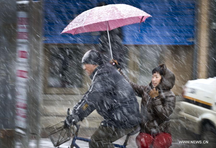 Citizens ride in snow in Jilin City, northeast China's Jilin Province, Nov. 12, 2012. A cold front is sweeping across the country's northern areas, bringing heavy snow and blizzards. (Xinhua/Sun Xin)  