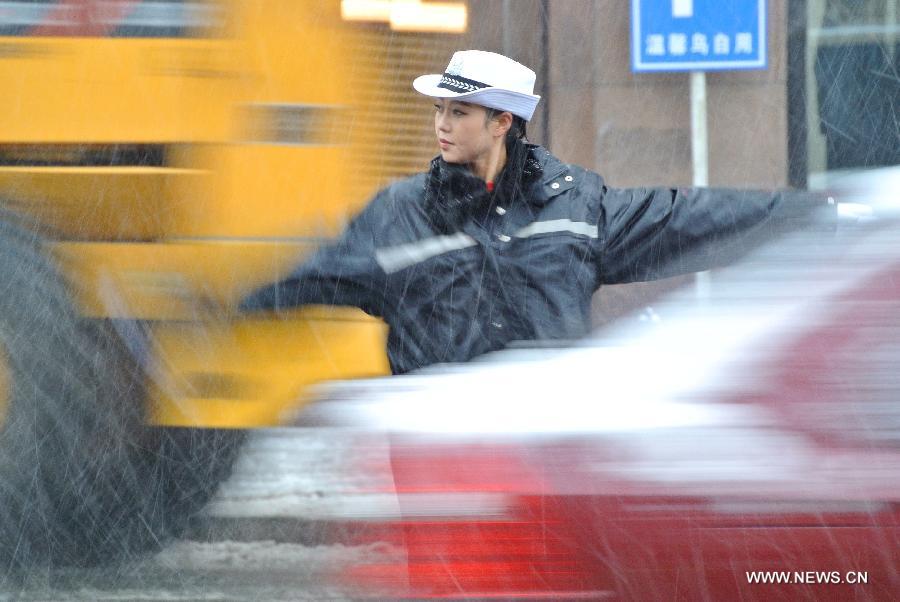 A policewoman is on duty as snow hits Harbin, capital of northeast China's Heilongjiang Province, Nov. 12, 2012. A cold front is sweeping across the country's northern areas, bringing heavy snow and blizzards. (Xinhua/Yao Tingshan) 