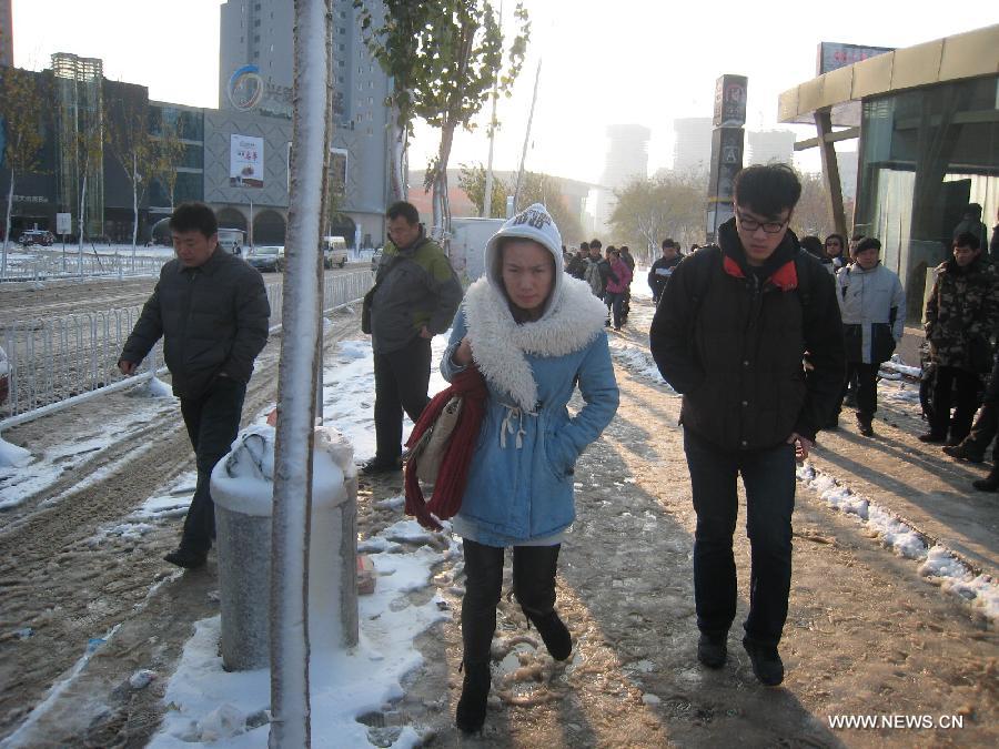 Pedestrians make their way on a snow-covered road in Shenyang, capital of northeast China's Liaoning Province, Nov. 12, 2012. A cold front is sweeping across the country's northern areas, bringing heavy snow and blizzards. (Xinhua/Cao Yang)  