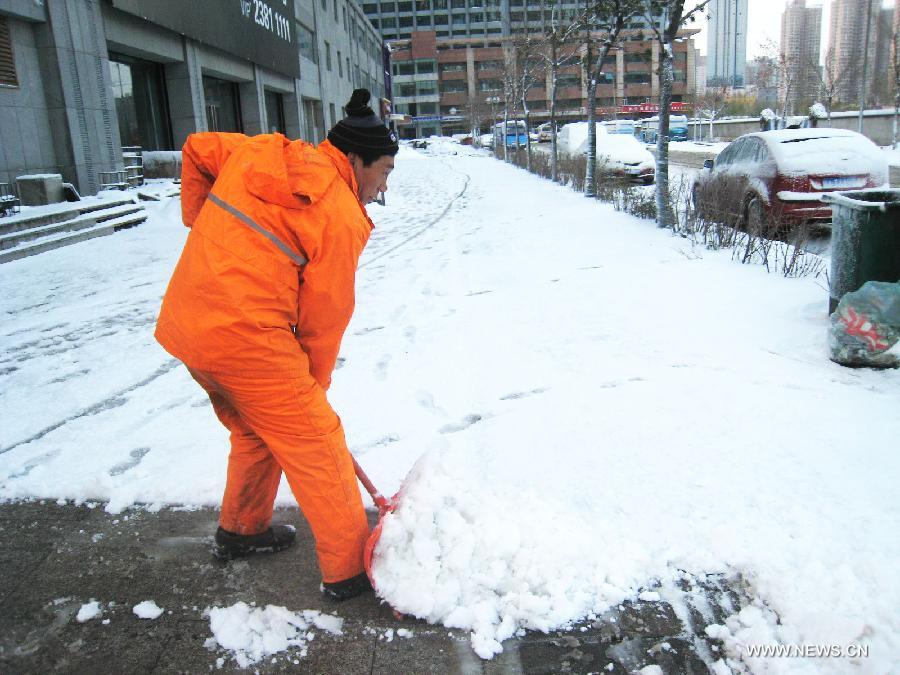 A sanitation worker cleans snow on a road in Shenyang, capital of northeast China's Liaoning Province, Nov. 12, 2012. A cold front is sweeping across the country's northern areas, bringing heavy snow and blizzards. (Xinhua/Cao Yang)  