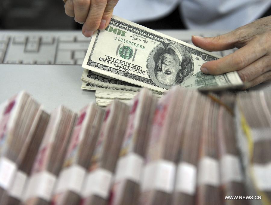 A worker counts the U.S. dollars at a bank in Qionghai City, south China's Hainan Province, Nov. 12, 2012. The Chinese currency Renminbi, or the yuan, strengthened 92 basis points to 6.2920 against the U.S. dollar on Monday, according to the China Foreign Exchange Trading System. (Xinhua/Meng Zhongde) 