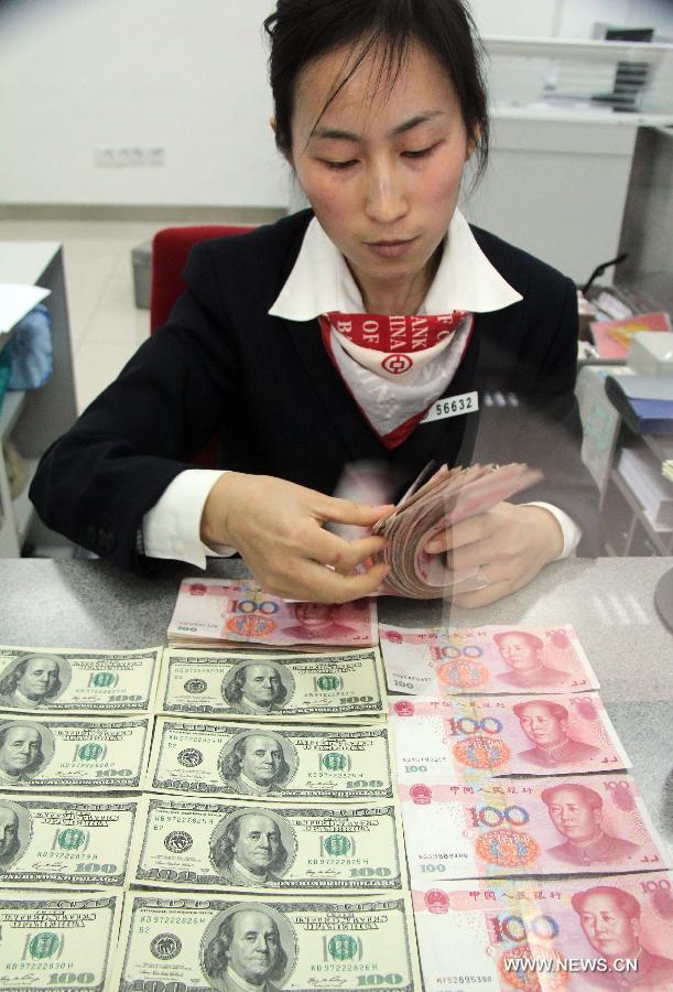 A worker counts the Chinese currency Renminbi, or the yuan, at a bank in Tancheng County of Linyi City, east China's Shandong Province, Nov. 12, 2012. The Renminbi strengthened 92 basis points to 6.2920 against the U.S. dollar on Monday, according to the China Foreign Exchange Trading System. (Xinhua/Zhang Chunlei) 