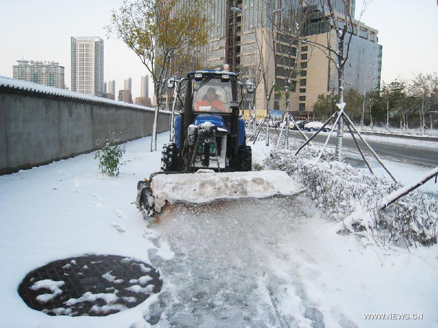 A bulldozer cleans snow beside a road in Shenyang, capital of northeast China's Liaoning Province, Nov. 12, 2012. A cold front is sweeping across the country's northern areas, bringing heavy snow and blizzards. (Xinhua/Cao Yang)  
