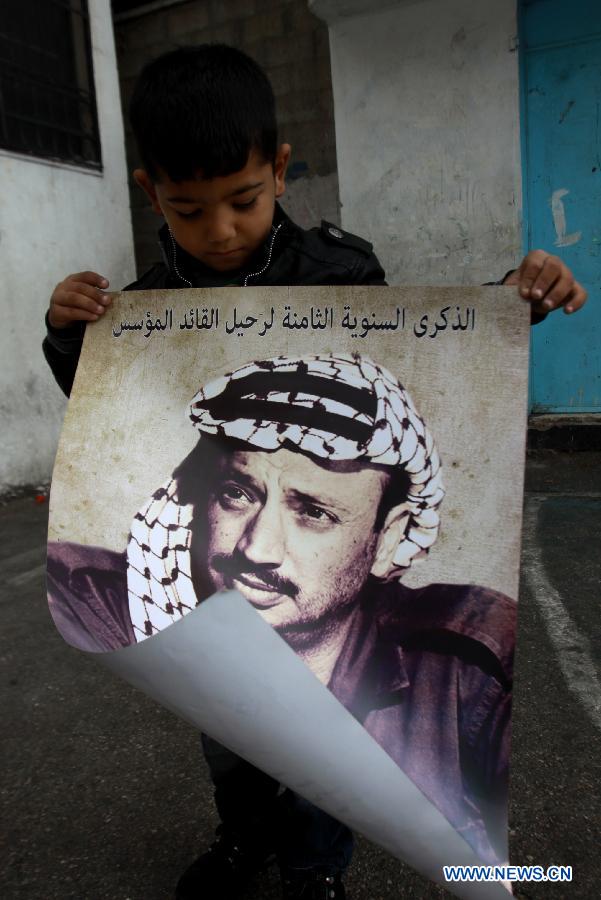A Palestinian boy holds a poster showing late Palestinian leader Yasser Arafat in West Bank city of Nablus, on Nov. 11, 2012, marking the eighth anniversary of Arafat's death. (Xinhua/Nidal Eshtayeh)
