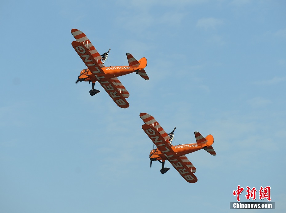 Photo taken on Nov. 11, 2012 shows the wingwalkers of Beritling Jet Tem, a famous European aerobatic team, putting on wonderful performance on the wings of biplaines during a test flight for the Airshow China 2012. The airshow kicked off on Tuesday morning in south China’s Zhuhai. (Photo/Chinanews.com)