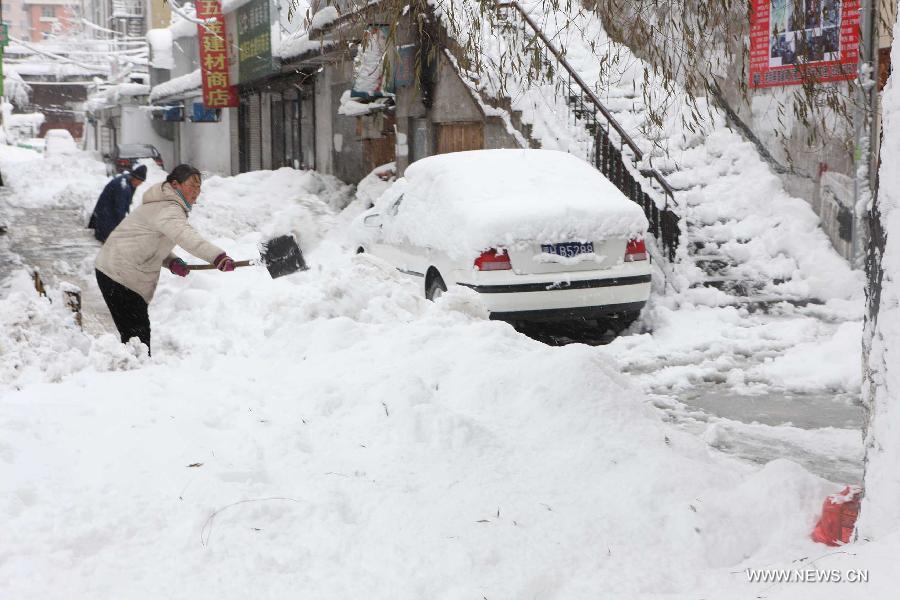 Residents clean snow on a raod in Hegang, northeast China's Heilongjiang Province, Nov. 13, 2012. Snowstorms in recent days have affected road traffic and caused difficulties to local people in northeast China. (Xinhua/Fang Baoshu) 