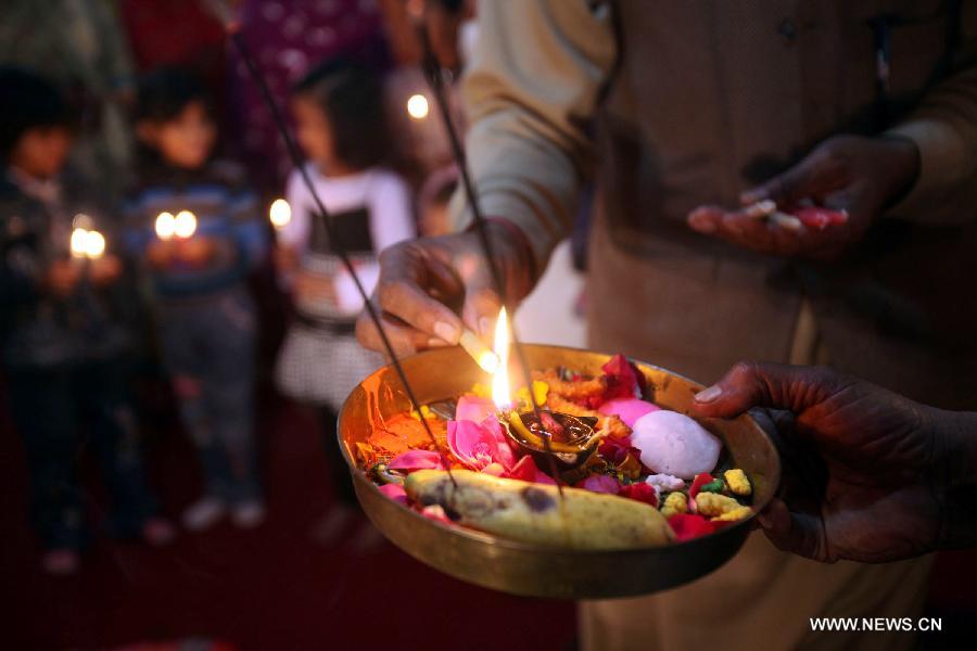 A Pakistani Hindu devotee lights a lamp to celebrate the Hindu festival of Diwali at a temple, in northwest Pakistan's Peshawar, on Nov. 13, 2012. People light lamps and offer prayers to the goddess of wealth Lakshmi in the Hindu festival of Diwali, the festival of lights, which falls on Nov. 13 this year. (Xinhua/Umar Qayyum)