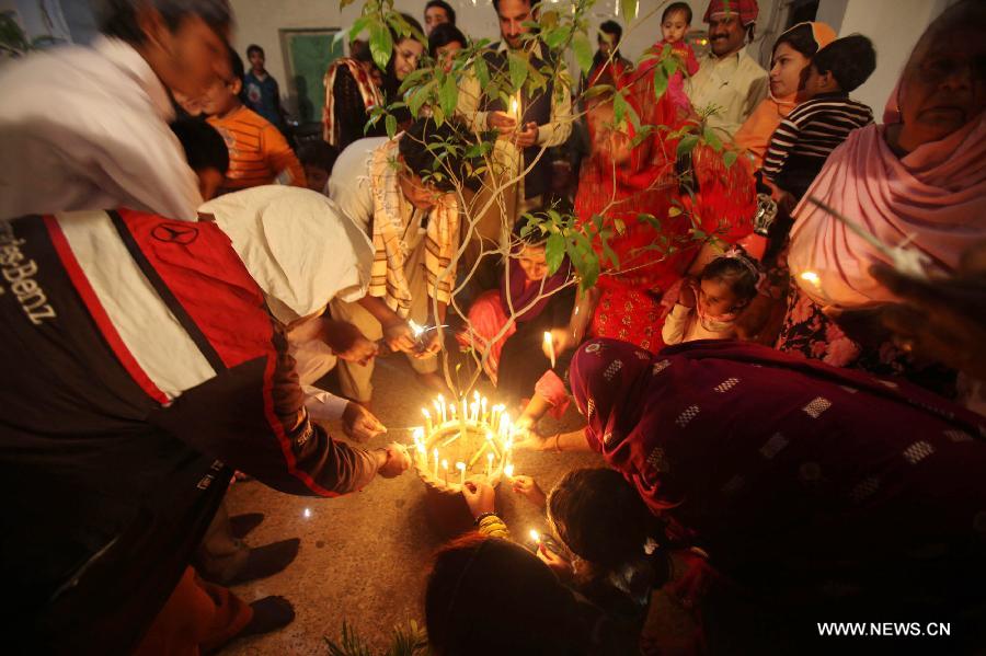 Pakistani Hindu devotees light candles around a tree to celebrate the Hindu festival of Diwali, in northwest Pakistan's Peshawar, on Nov. 13, 2012. People light lamps and offer prayers to the goddess of wealth Lakshmi in the Hindu festival of Diwali, the festival of lights, which falls on Nov. 13 this year. (Xinhua/Umar Qayyum)