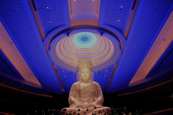 Psychedelic patterns shift on an LCD display hovering over Buddha's head at Dayuan Cultural Garden. (Photo: CRIENGLISH.com/William Wang)