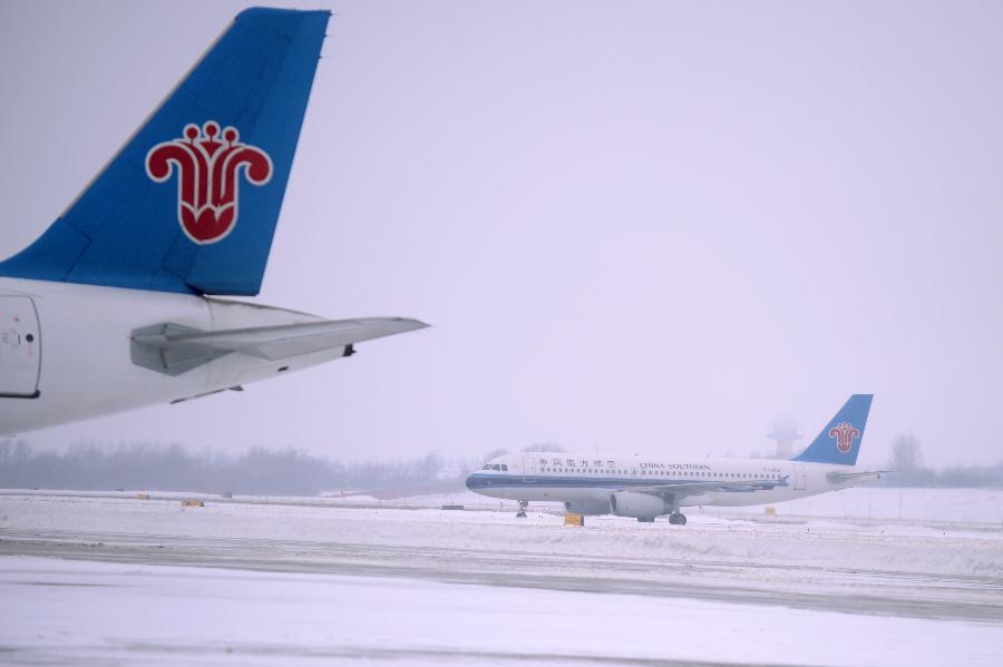 A plane lands in Changchun Longjia International Airport in Changchun, capital of northeast China's Jilin Province, Nov. 14, 2012. Most of flights departing from and arriving at the airport were not affected by the heavy snowstorm that precipitated from Sunday until Tuesday. (Xinhua/Lin Hong)  