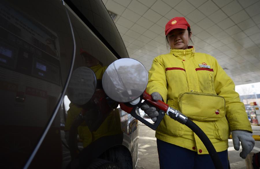A worker fills a car at a gas station in Yinchuan, capital of northwest China's Ningxia Hui Autonomous Region, Nov. 15, 2012. China will cut the retail prices of gasoline by 310 yuan (49.2 U.S. dollars) and diesel by 300 yuan per tonne starting from Friday, the National Development and Reform Commission (NDRC), the country's top economic planner, said Thursday. (Xinhua/Wang Peng)