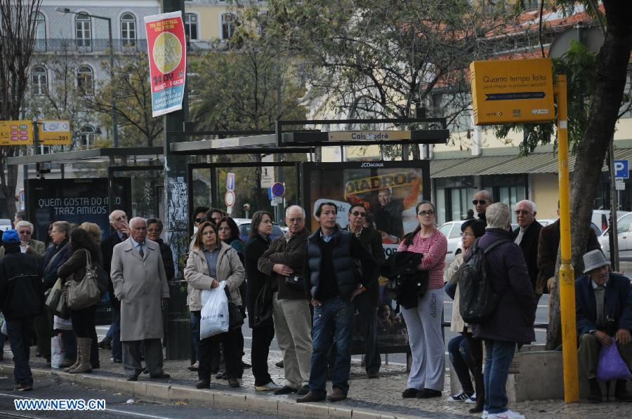 People wait at a bus stop during a general strike in Lisbon, Portugal, on Nov. 14, 2012. (Xinhua/Zhang Liyun)