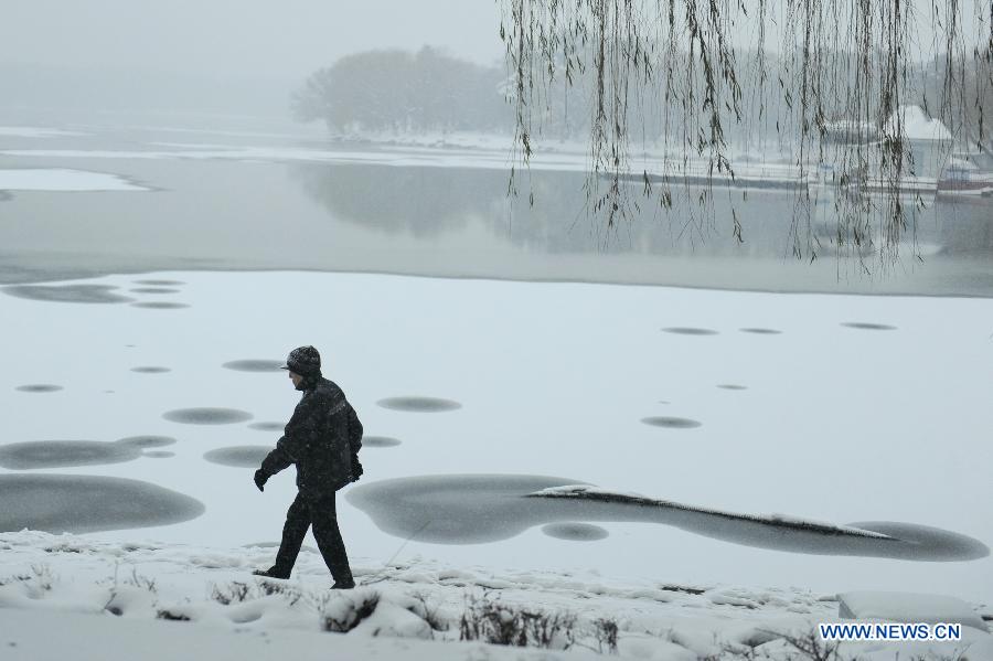 A citizen walks on a snow-covered road in Changchun, capital of northeast China's Jilin Province, Nov. 16, 2012. A snowfall hit central and eastern Jilin on Friday. (Xinhua/Zhang Nan) 
