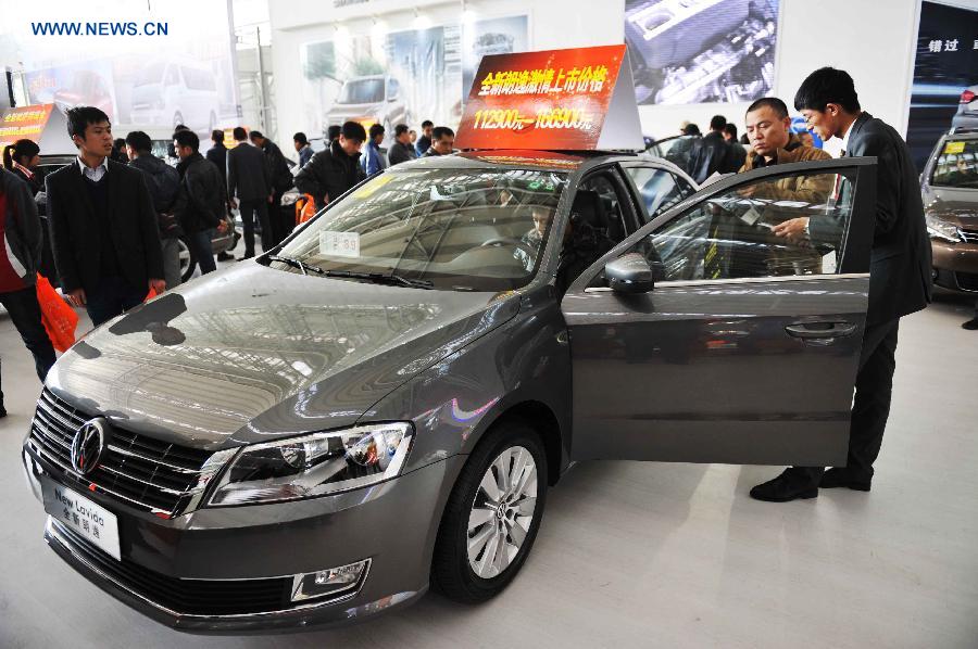 Visitors check a car during the 3rd Harbin Autumn Automobile Exhibition in Harbin, capital of northeast China's Heilongjiang Province, Nov. 20, 2012. The exhibition, as well as the 10th Harbin automobile purchasing week, kicked off on Tuesday.(Xinhua/Wang Jianwei) 