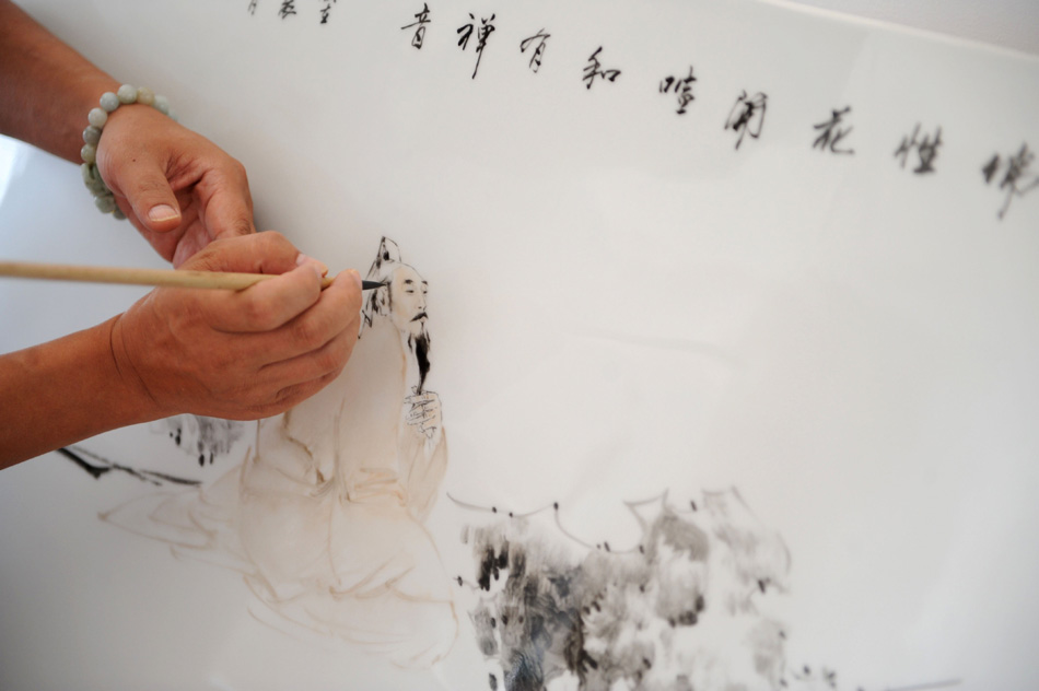 Li Bin draws on a porcelain plate at a workroom in Jingdezhen, east China's Jiangxi Province, Aug. 18, 2012. (Xinhua/Zhang Ruiqi)