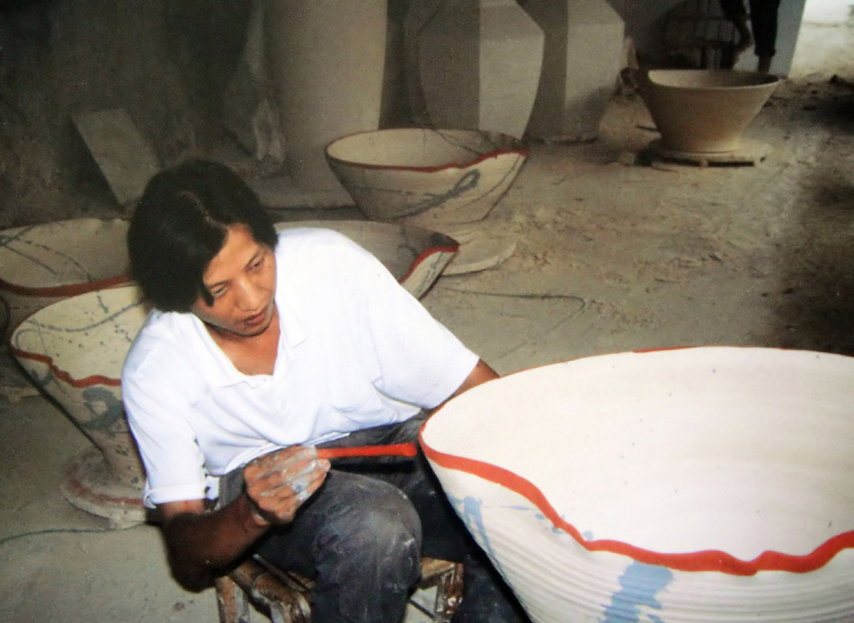Li Bin draws on a porcelain at a workshop in Jingdezhen, east China's Jiangxi Province, Aug. 7, 2010. (Xinhua/Qiao Sheng)