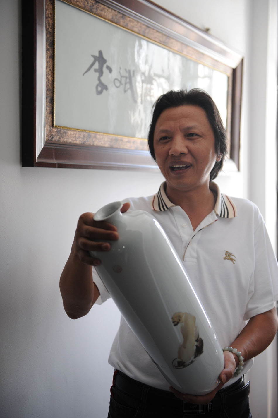 Li Bin introduces his porcelain works at a workroom in Jingdezhen, east China's Jiangxi Province, Aug. 18, 2012. (Xinhua/Zhang Ruiqi)