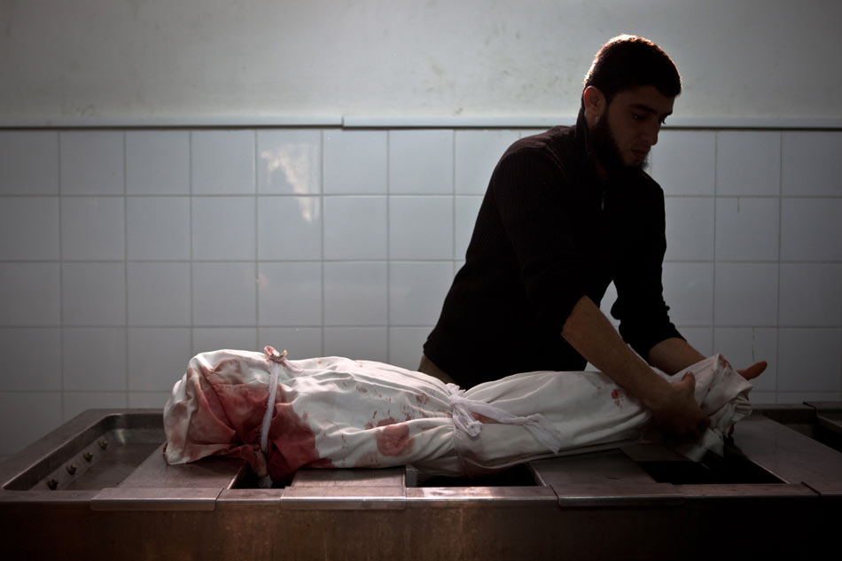 A hospital staff is working on dead body of a girl who was killed in an Israeli air strike in a hospital in Gaza City on Nov. 19, 2012. (Xinhua/AFP)