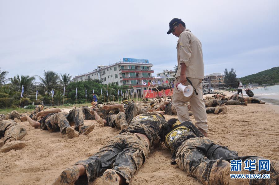 Trainees crawl on the beach with eyes wrapped by tapes. (Xinhua/Liu Changlong)