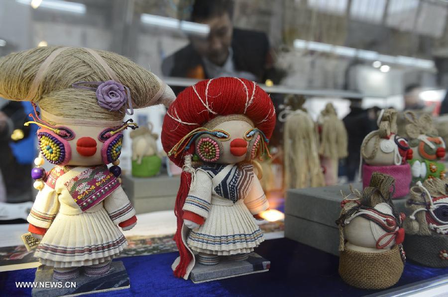 Visitors look at artworks by Guizhou folk artists during the show of Guizhou National Folk Handicrafts in Beijing, capital of China, Nov. 21, 2012. (Xinhua/Li Jundong) 