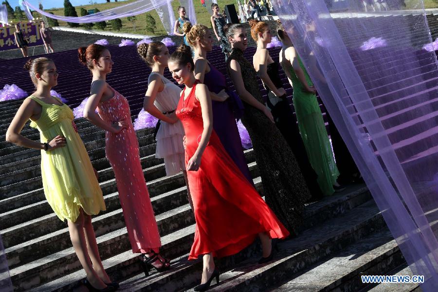 Contestants for the final of New Silk Road Miss World Competition rehearse at the Meizihu Garden in Pu'er, southwest China's Yunnan Province, Nov. 22, 2012. The contestants will also attend joint performance with country music bands at the 1st Pu'er International Country Music Festival. (Xinhua/Li Mingfang)