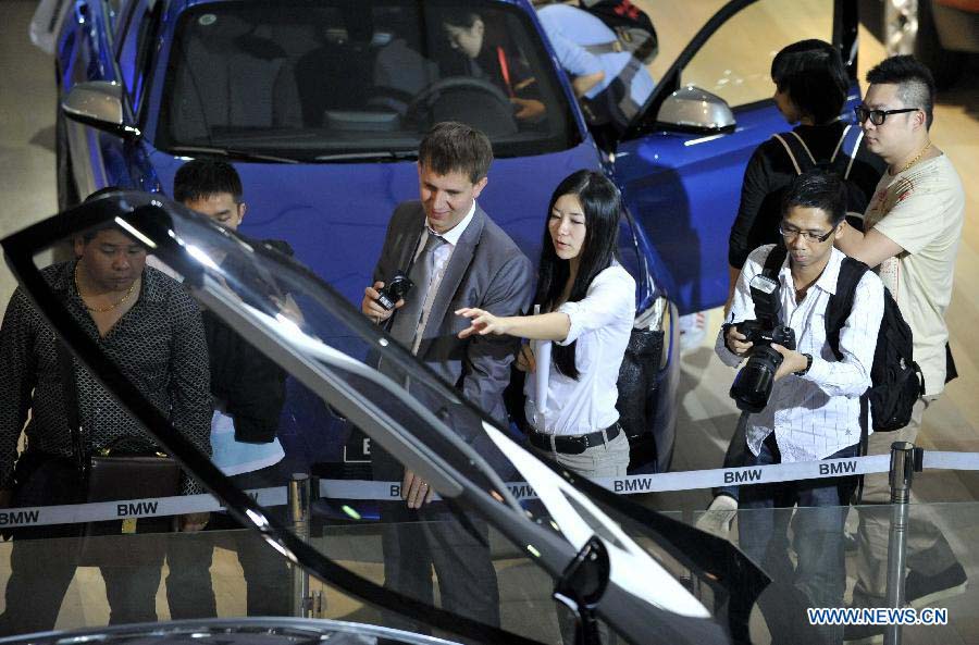 Visitors look at a car during the press day of the 10th China (Guangzhou) International Automobile Exhibition in Guangzhou, capital of south China's Guangdong Province, Nov. 22, 2012. The exhibition is expected to be held from Nov. 23 to Dec. 2, 2012. (Xinhua/Chen Yehua) 