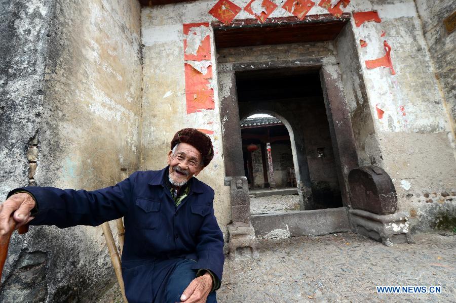 A 93-year-old man talks a story about walled villages in Yangcun Town of Longnan County in Ganzhou City, east China's Jiangxi Province, Nov. 21, 2012. The Gannan (southern Jiangxi Province) Hakka walled villages, a special architectural type, was included into China's World Cultural Heritage Tentative List on Nov. 17, 2012. The whole structure of the building resembles a small fortified city, containing halls, storehouses and living areas. It is regarded as the "cradle of Hakka". According to official statistics, there are over 600 such buildings in Gannan at present. (Xinhua/Song Zhenping)