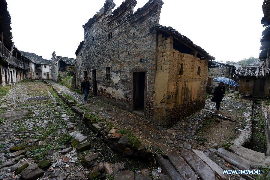 Photo taken on Nov. 21, 2012 shows the outer walls of a walled village in Yangcun Village of Longnan County in Ganzhou City, east China's Jiangxi Province. This four-floor clay building has a history of over 320 years with a maximum capacity of 136 families. The Gannan (southern Jiangxi Province) Hakka walled villages, a special architectural type, was included into China's World Cultural Heritage Tentative List on Nov. 17, 2012. The whole structure of the building resembles a small fortified city, containing halls, storehouses and living areas. It is regarded as the "cradle of Hakka". According to official statistics, there are over 600 such buildings in Gannan at present. (Xinhua/Song Zhenping) 