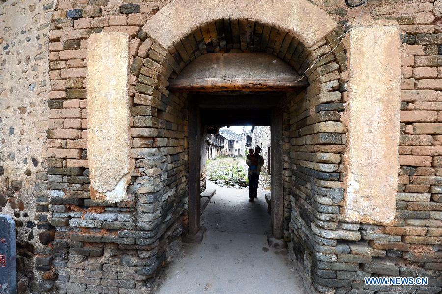 Photo taken on Nov. 21, 2012 shows the brick-made gate of of a walled village in Yangcun Town of Longnan County in Ganzhou City, east China's Jiangxi Province. The Gannan (southern Jiangxi Province) Hakka walled villages, a special architectural type, was included into China's World Cultural Heritage Tentative List on Nov. 17, 2012. The whole structure of the building resembles a small fortified city, containing halls, storehouses and living areas. It is regarded as the "cradle of Hakka". According to official statistics, there are over 600 such buildings in Gannan at present. (Xinhua/Song Zhenping) 