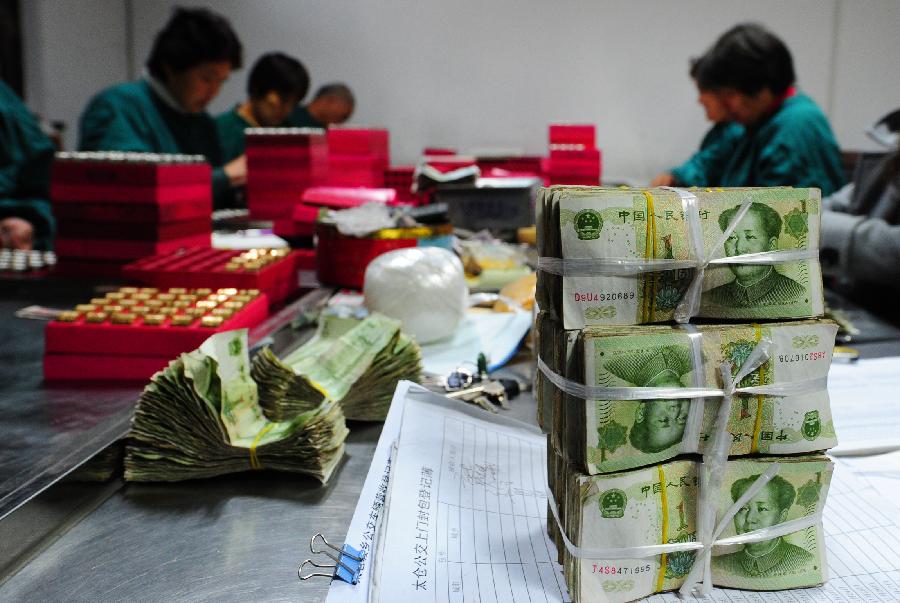 Photo taken on Nov. 18, 2012 shows bundles of sorted-out one-yuan notes at the cash center of the Taicang Public Bus Company in Taicang, east China's Jiangsu Province. Each day, staff members at the cash center of the Taicang Public Bus Company need to sort out notes and coins collected from all bus fare boxes of the company. It takes four hours on average to finish a day's work: the total earnings of 52 bus lines. (Xinhua/Ji Haixin) 