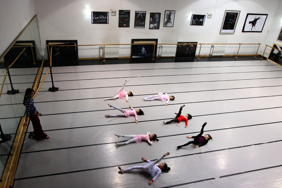 Kids practise during a ballet class in Beijing Dance Theatre (BDT) in Beijing, capital of China, March 4, 2012. BDT offers facilities and guidance to children who want to learn the art of dance in the weekends. (Xinhua/Xu Zijian)
