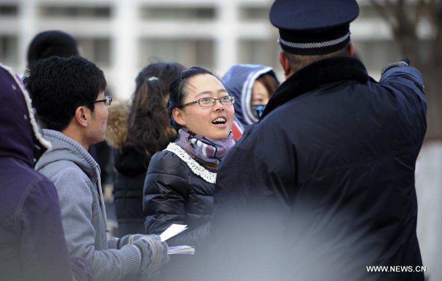 An examinee asks about the way to the examination room of the 2013 civil service exams in Yinchuan, capital of northwest China's Ningxia Hui Autonomous Region, Nov. 25, 2012. More than 1.5 million people took part in the nationwide exams in China to qualify for about 20,000 state civil service posts on Sunday. (Xinhua/Li Ran)  