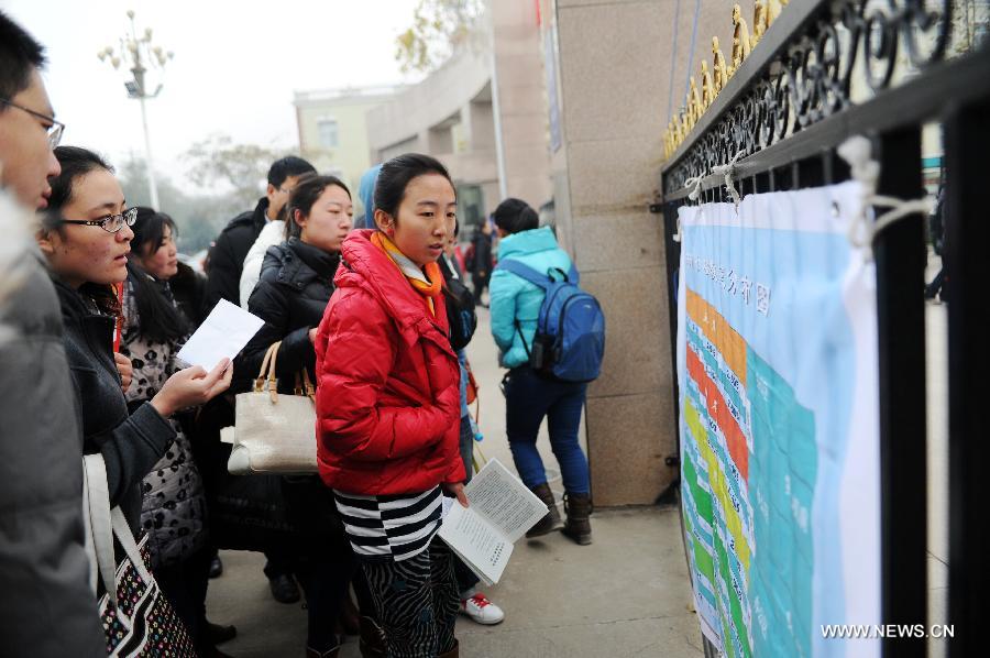 Examinees watch the map of examination rooms of the 2013 civil service exams in Shijiazhuang, capital of north China's Hebei Province, Nov. 25, 2012. More than 1.5 million people took part in the nationwide exams in China to qualify for about 20,000 state civil service posts on Sunday. (Xinhua/Zhu Xudong) 
